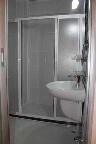 a bathroom with a shower and a white sink at Ferah Hotel in Patara
