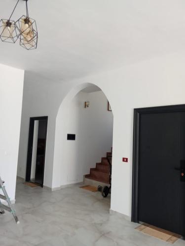 a hallway with a staircase and a black door at Rooms New DiamonD in Durrës