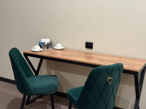 a desk with two chairs and a table at Da Vinci Hotel in Almaty