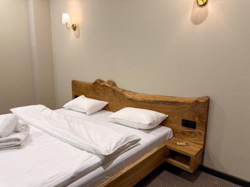 two beds in a room with white sheets and pillows at Da Vinci Hotel in Almaty