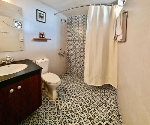 a bathroom with a shower with a toilet and a sink at Magpie Retreat in Bhīm Tāl