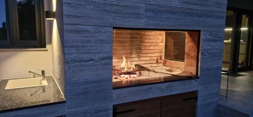 a stone fireplace in a bathroom with a sink at Holiday house Vito Zadar in Zadar