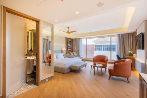 a hotel room with a bed and a living room at Goldfinch Panjim Goa in Old Goa