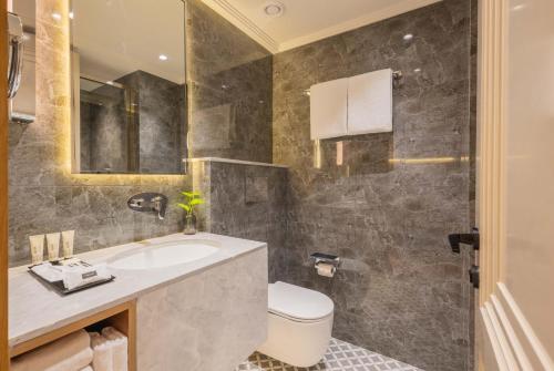 a bathroom with a sink and a toilet at Goldfinch Panjim Goa in Old Goa