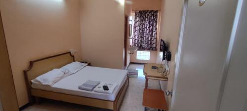 a small room with a bed and a telephone at Hotel shri annalakshmi lodge in Theni