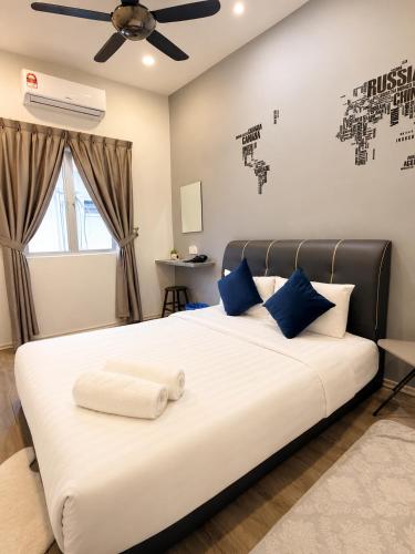 a bedroom with a large white bed with blue pillows at Casa Le Rock in Kuah