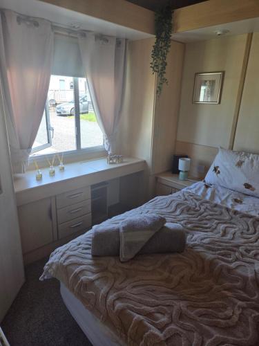 a bedroom with a large bed with a window at Serenity in Monreith