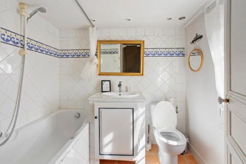 a bathroom with a sink and a tub and a toilet at La Villa Andéria in Callian