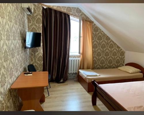 a small room with a bed and a desk and a window at Comfort in Reni