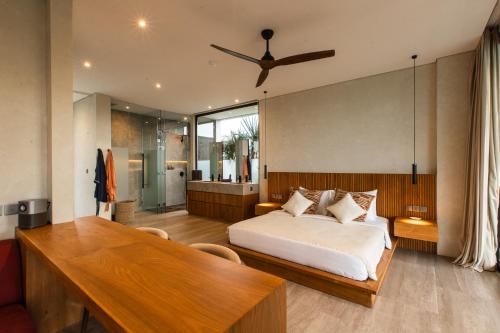 a bedroom with a bed and a wooden table at Villa Famara Pererenan, Canggu by Blacksand in Tumbak Bayuh