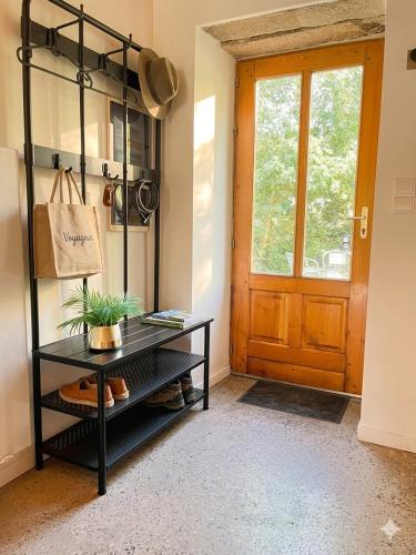aoyer with a black table and a door at Petite maison ardéchoise in Saint-Michel-de-Chabrillanoux