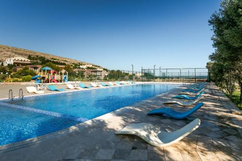 a large swimming pool with lounge chairs in a resort at Khazri Resort & Villas in Baku