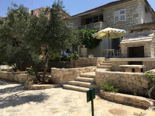 a patio with stairs and an umbrella in front of a house at Apartments Laura in Korčula