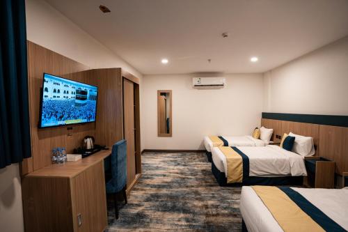 a hotel room with two beds and a flat screen tv at Alhijra View 2 - فندق الهجرة فيو 2 in Mecca