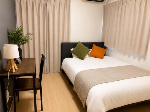 a bedroom with a bed and a table with a desk at OTE HOUSE shime in Shime