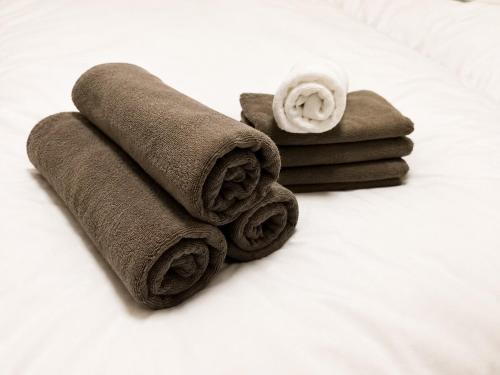 a pile of towels sitting on top of a bed at OTE HOUSE shime in Shime