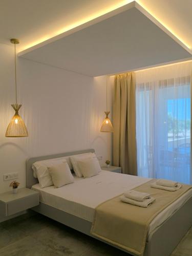 a bedroom with a large white bed with two lamps at Calm Luxury Villas in Limenaria