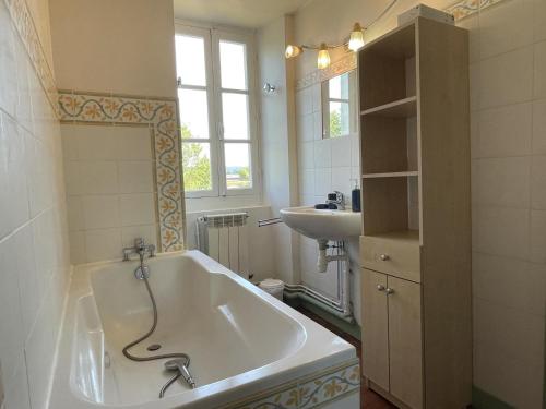 a bathroom with a bath tub and a sink at Chez cazalets in Susmiou