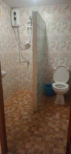 a bathroom with a toilet and a shower stall at Relax Inn in Ban Phe