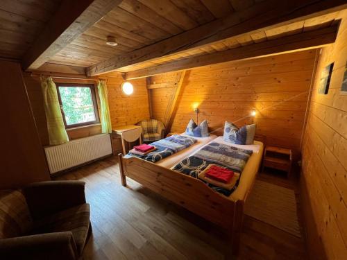 a bedroom with a bed in a wooden cabin at Reiter- und Ferienhof Wacker in Schöna