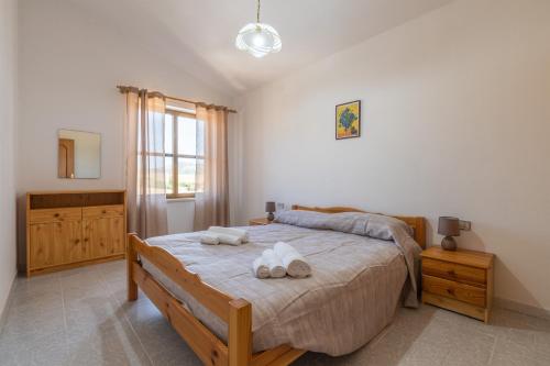 a bedroom with a bed with two towels on it at Casa Vacanza Iris in Perdaxius