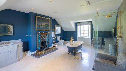 a bathroom with blue walls and a tub and a couch at Lissadell on The Beach in Lissadell