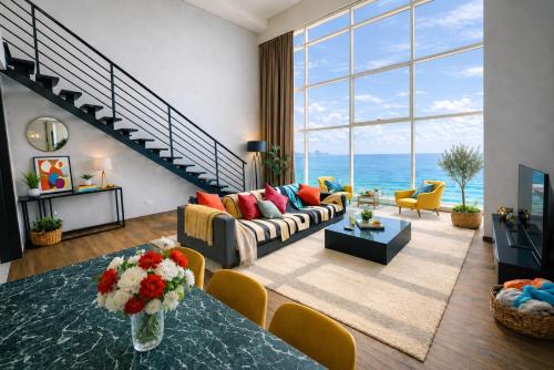 a living room with a couch and a table at Panoramic Sea view 2BR Duplex High Floor George Town 203A Maritime Suite in George Town