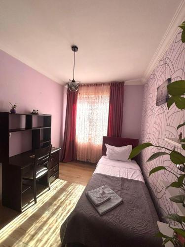 a bedroom with a bed and a dresser in it at Cozy Family Apartment in Tbilisi City