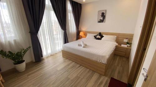 a bedroom with a bed and a large window at Zanya villa & coffee in Da Lat