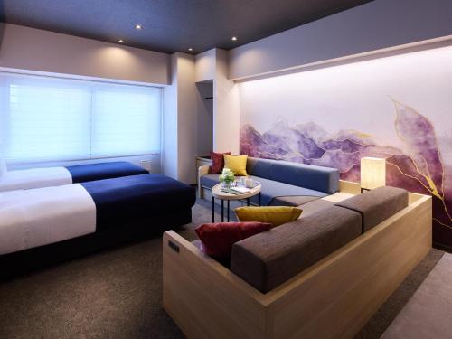a bedroom with a bed and a couch at Minn Namba South in Osaka