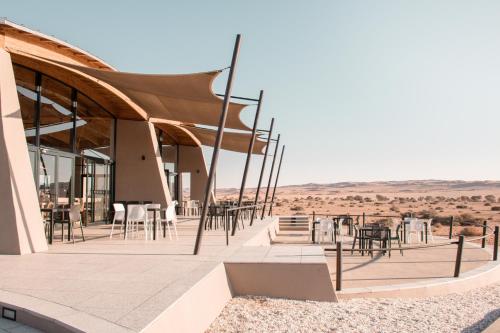 a building with tables and chairs in the desert at The Desert Grace in Solitaire