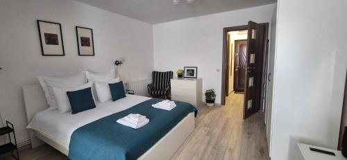 a bedroom with a bed with blue and white sheets at ZARA STUDIO BRASOV in Braşov