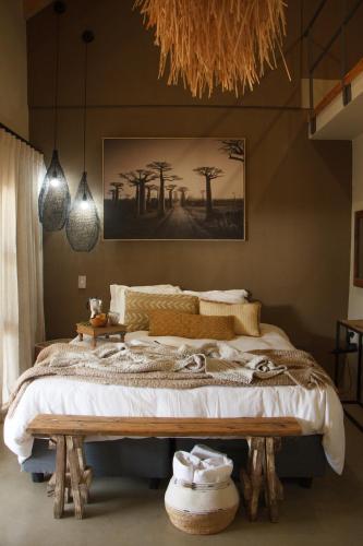 a bedroom with a large bed and a painting on the wall at Stroomrivier Lodge in Boshoek