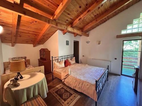 a bedroom with a bed and a table with a lamp at Casa Verde in Vrîncioaia Negrileşti