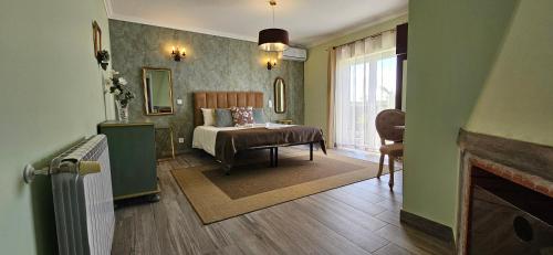 a bedroom with a bed and a room with a fireplace at Quinta Sao Martinho in Reguengo Grande