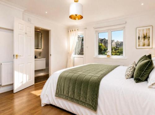 a white bedroom with a large bed and windows at Waterside House in Southampton