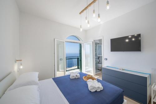 a bedroom with a large bed with towels on it at Villa CristAl in Praiano
