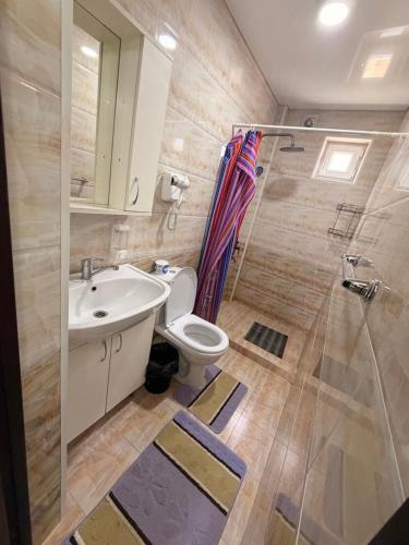 a bathroom with a sink and a toilet and a shower at Yasina in Bosteri