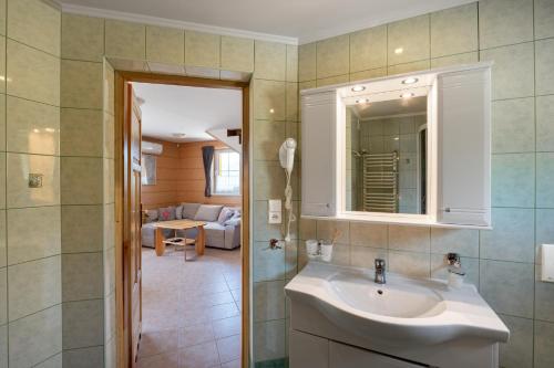 a bathroom with a sink and a living room at Góralskie Domki in Szczawnica