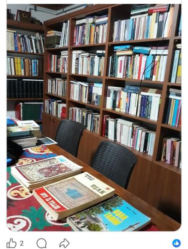 a library with a table and bookshelves filled with books at Uşak Sanat Konağı in Uşak