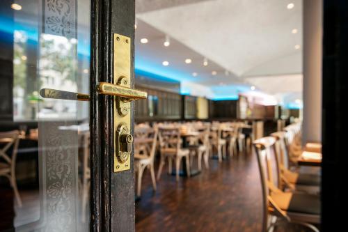 a door to a restaurant with tables and chairs at ARCOTEL Wimberger Wien in Vienna