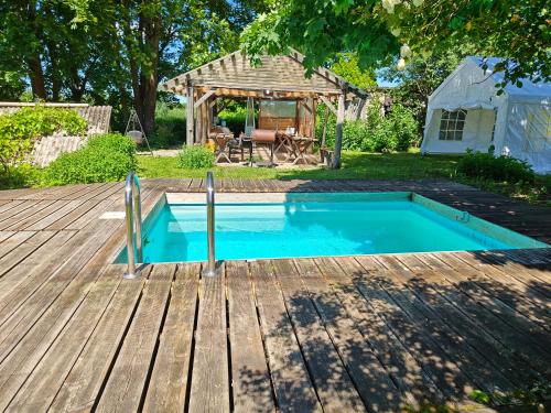 a swimming pool on a deck next to a house at Vahtramäe saun in Siniküla