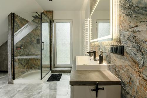 a bathroom with a sink and a shower at Apartament Nowinka in Tatary
