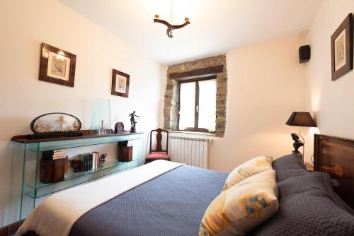 a bedroom with a bed and a couch and a window at IZURRENEA Casa Rural in Arano
