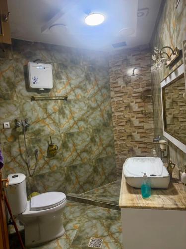 a bathroom with a toilet and a sink at Kite Residence - Secure Stay in Kabul