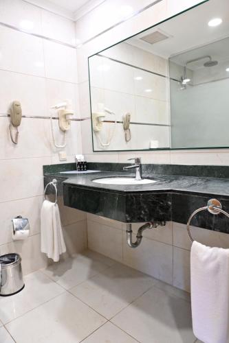 a bathroom with a sink and a large mirror at Pine Beach Belek in Belek