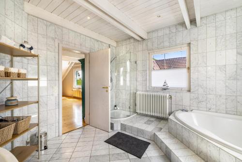 a white bathroom with a tub and a window at Villa Encanto in Albstadt