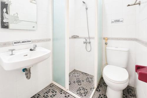 a white bathroom with a toilet and a sink at Urbanview Hotel RDN Oasis Cisarua by RedDoorz in Brujul