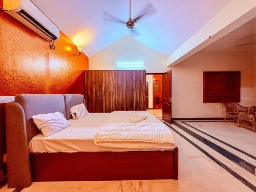 a bedroom with a bed with a ceiling fan at CK Beach House in Chennai