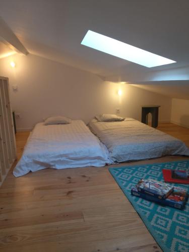 two beds sitting in a room with a ceiling at Entire maisonette in Tarn in Busque